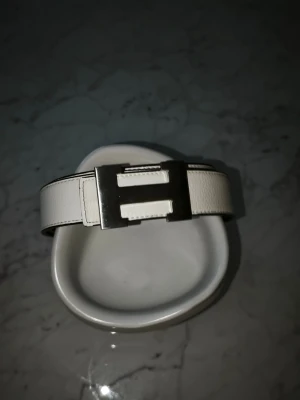 Vitt H Designer bälte 115 - Snyggt H bälte, passar alla stiler och får dig att sticka ut på ett unikt och stiligt sätt