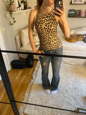 Leopardmönstrad body - Snygg body med leopardmönster. Bodyn har en tight passform och sitter perfekt. Tillverkad i mjukt och stretchigt material som sitter skönt mot kroppen.