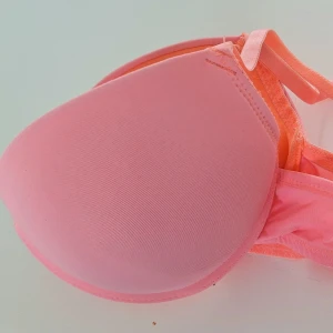 Rosa push-up bh med vaddering 75B  - Snygg rosa push-up bh med vadderade kupor och justerbara axelband. Bh:n har släta kupor och är tillverkad i ett mjukt, stretchigt material för extra komfort. Perfekt för dig som vill ha lite extra lyft och en feminin look. Aldrig använd men lapparna är bortklippta. 