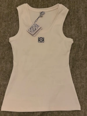 Vit ribbad linnetopp från Loewe - Snygg vit ribbad linnetopp från Loewe med broderad logga framtill. 