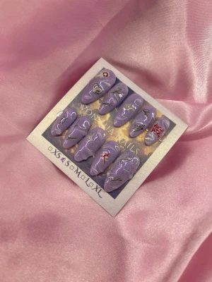 DomBae(S);Medium Almond - Handgjort set press-on naglar i lila med cateye, glitter och motiv som hjärta, Skz. Naglarna har en medium almondform och coola detaljer i svart, vitt och rött. Perfekt för dig som vill ha unika och kreativa naglar. S: 15 mm, 11,5 mm, 12 mm, 11 mm, 9 mm 