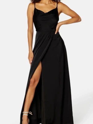 Svart balklänning med slits - Nyskick!! Säljer denna stilrena, svarta långklänning i satinliknande tyg. Har en vacker draperad ringning och en hög slits framtill som ger en elegant men ändå modern look. Axelbanden är tunna och klänningen faller fint längs kroppen. Endast provad, aldrig använd och har lapparna kvar. Helt slutsåld på hemsidan🙈OBS, inte min storlek på klänningen därför håller jag in den lite på bilderna!