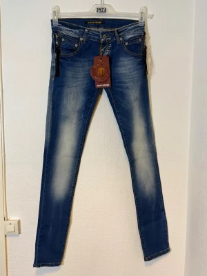 Blå skinny jeans från Domina -  Midjan 36 cm  Längd 100 cm  Benvidd 21 cm 