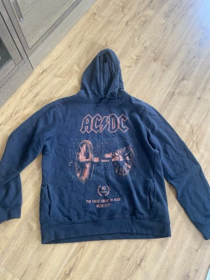 Svart AC/DC hoodie med tryck - Svart AC/DC hoodie. Använd för länge sen och inte längre.