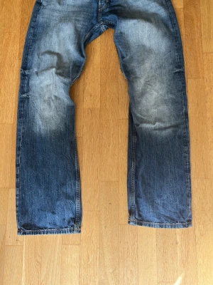 Straight/bootcut jeans från weekday - Säljer ett par blå jeans med raka/bootcut ben och snygga slitningar på framsidan. Jeansen har klassisk femficksdesign och är tillverkade i denim. Perfekta för en avslappnad och cool stil. Från weekday. Modell är meteor.priset är inte hugget i sten