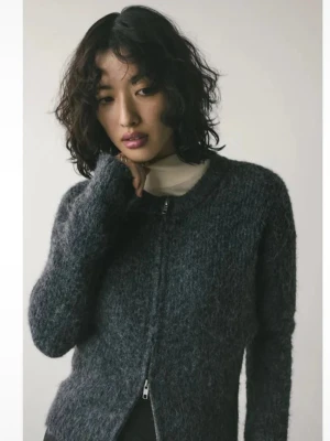Mörkgrå fluffig zip-kofta från Weekday - Mysig mörkgrå kofta från Weekday med fluffig struktur och dragkedja framtill. Rund halsringning och långa ärmar ger en avslappnad look. Perfekt att slänga över en t-shirt eller topp för extra värme och stil.