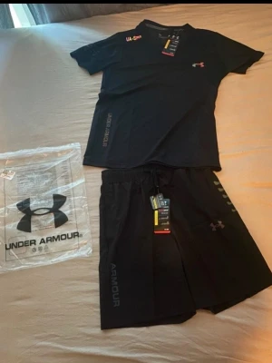 Svart träningsset från Under Armour - Säljer ett Under Armour sett helt oanvänt. T-shirt och Shorts I stoelek M.