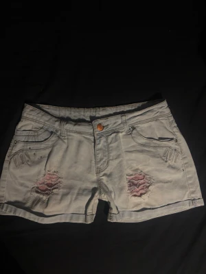 Lågmidjade Ljusblåa jeanshorts - Säljer ett par lågmidjade ljusblåa jeansshorts med slitna detaljer🩷