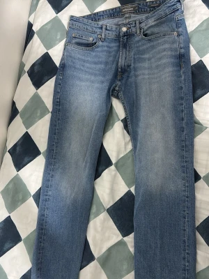 Ljusblå raka jeans från Acne Studios - Säljer ett par ljusblå jeans från Acne Studios med klassisk femficksmodell och raka ben. Jeansen har en snygg tvätt med subtila slitningar och silverfärgade detaljer. Perfekta för en avslappnad och trendig look.