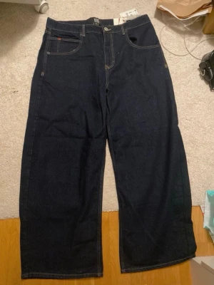 Mörkblåa baggy low rise jeans  - Säljer ett par mörkblåa wide leg baggy jeans från Urban Outfitters med låg midja och breda ben. 