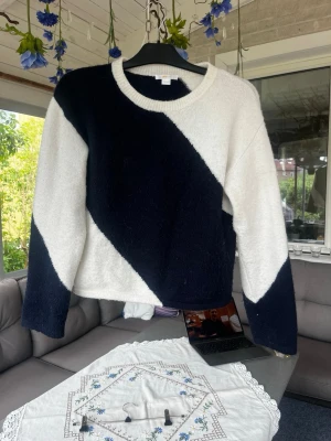 Svartvit stickad tröja med diagonal design - Säljer den trendiga tröjan från ginayoung med breda diagonala ränder. Perfekt för alla tillfällen. Barnstorlek 157/164 men passar som en xs