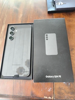 Samsung Galaxy S24 FE svart - Samsung Galaxy S24 FE i stilren svart färg med tre kameror på baksidan. Telefonen har en modern, slimmad design i glas och metall. Levereras i originalkartong med USB-C kabel och SIM-verktyg. Perfekt för dig som vill ha en kraftfull Android-mobil.