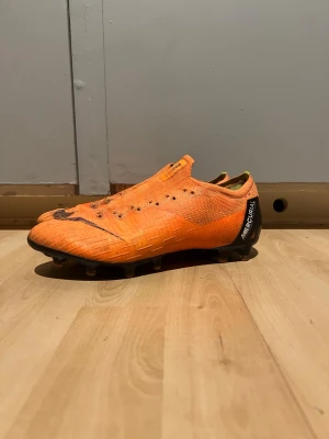 Nike mercurial vapor 12 elite - Säljer ett par Nike Mercurial vapor 12 Elite i storlek 40. Tyvärr har båda snörena gått sönder så tagit bort dem. Inget trasigt där man fäster snörena. Dem är använda men i mycket gott skick. Mycket dubbar kvar och inga slitningar i fram vid tårna.