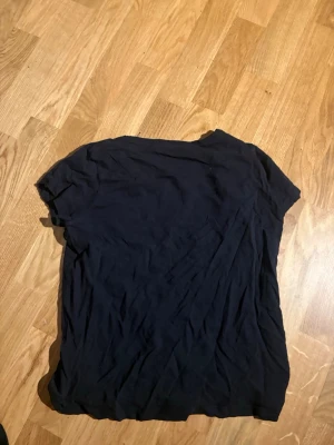 Svart basic t-shirt - En enkel svart t-shirt med korta ärmar och rund hals. Perfekt till jeans eller shorts för en avslappnad look. Tillverkad i mjukt material som känns skönt mot huden.