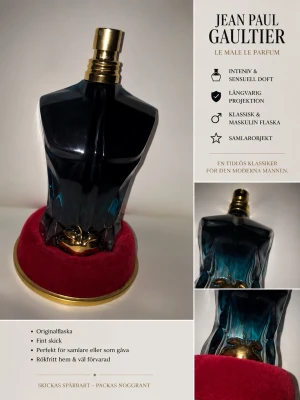 Jean Paul Gaultier Le Male Parfum 75ML - Maskulin parfymflaska formad som en överkropp i mörkblått glas med guldfärgad spraykork. Flaskan står på en rund röd sammetsliknande bas med guldkant. En ikonisk och klassisk design som sticker ut i badrumshyllan. Ca halva kvar