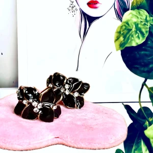 Tidlösa earcuffs med svarta blommor!  - Tidlösa guldfärgade earcuffs med svarta blommor i emalj & små stenar. Mått: 2 x 5 cm. Oanvända.