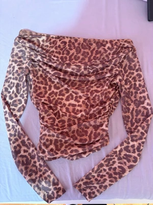 Leopardmönstrad mesh topp - Långärmad topp i mesh med leopardmönster. Toppen har draperad halsringning och figurnära passform. Den kom tyvärr inte till användning men kanske någon annan har användning till den! PM för fler bilder eller frågor ❤️ 