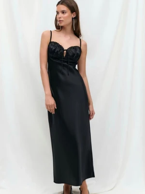 Svart långklänning med smala axelband - Stilren svart långklänning i satinliknande material med smala axelband och en liten nyckelhålsdetalj framtill.