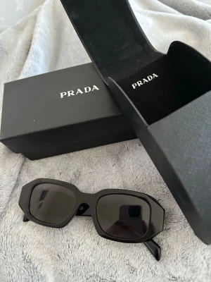 Svarta rektangulära solglasögon  - Snygga svarta solglasögon med rektangulära bågar och mörka glas, inspirerad av prada. Kommer med allt som finns i bilden. Skriv för mer bilder