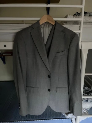 Cavaliere Italiensk 3 piece kostym  - Snygg grå kostym med klassisk tvåknäppt kavaj och matchande byxor med vest. Kavajen har smala slag, bröstficka och två framfickor. Byxorna har raka ben och bälteshällor. Perfekt för dig som vill ha en stilren och tidlös look. Pris kan diskuteras