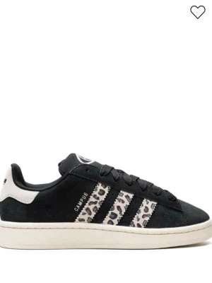 Adidas Campus svart leopard sneaker - Snygga Adidas Campus sneakers i svart mocka med de klassiska tre ränderna i leopardmönster. Skon har vit sula och vit detalj vid hälen med Adidas-logga. Perfekt för dig som vill sticka ut med en unik twist på en ikonisk modell.kan gå ner i pris,skorna e lite smutsiga men går att rengöra 