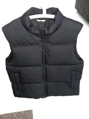 Dunväst  - Svart varm dunväst som knappt är använd. Storleken är Large men längden är i princip en Medium. 