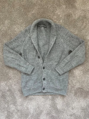 Tjock Stickad Kofta/Cardigan - En cardigan i en trendig modell. Den är lite tjockare och har även en tjockare krage. Fint skick och inte några synliga defekter. 