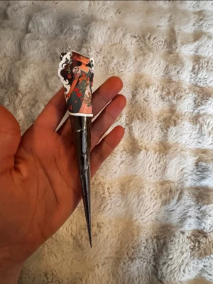 Henna kon - En brun henna kon med färgglad etikett, Perfekt för att skapa tillfälliga mönster på huden. Enkel att använda tack vare den smala spetsen.