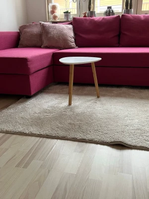  Bäddsoffa  med schäslong - Säljer en modern bäddsoffa i starkt rosa tyg med schäslong och två matchande rosa kuddar. Soffan kan enkelt göras om till en säng och har raka former. Perfekt för dig som vill ha extra sovplats och snygg inredning.