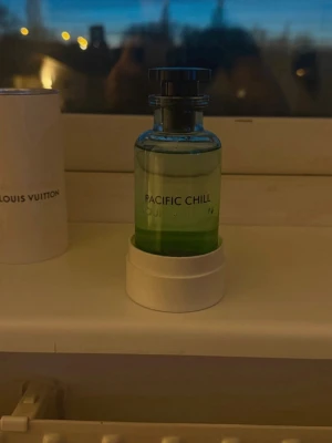 Louis Vuitton Pacific Chill parfym - Fräsch parfym från Louis Vuitton i doften Pacific Chill. Flaskan är cylindrisk i genomskinligt glas med en grön toning och svart lock. Stilig och modern design som sticker ut på hyllan. Perfekt för dig som gillar exklusiva dofter och snygga flaskor.