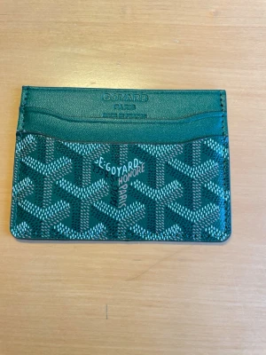 Grön kortfodral - Snyggt grönt kortfodral med klassiskt mönster och flera kortfack. Fick den av min kompis vill sälja den jag tycker inte den var snygg 