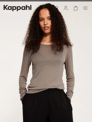 Beige långärmad topp från Kappahl - En enkel och stilren beige långärmad topp från Kappahl. Toppen har rund halsringning och är tillverkad i mjuk bomullsmix som känns skön mot huden. Passformen är normal och toppen är perfekt att matcha med både jeans och kjol. Endast testad (lös passform )