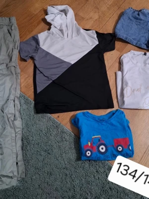 Svart, grå och vit hoodie-topp - Snygg hoodie-topp med korta ärmar i svart, grått och vitt blockmönster. Perfekt för en avslappnad streetstyle-look. Mjuk och skön med huva, passar dig som gillar en sportig vibe.