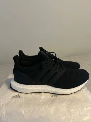 Svarta Adidas Ultraboost sneakers - Säljer ett par svarta Adidas Ultraboost sneakers med klassisk vit Boost-sula. Skorna är helt nya och är i storlek 42 vid intresse eller frågor är det bara att höra av Sig.