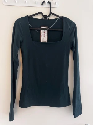 Långärmad tröja - Långärmad tight tröja med fyrkantig urringning. Lite tjockare i materialet (typ dubbeltyg) och supermjuk. Aldrig använd och lappar kvar