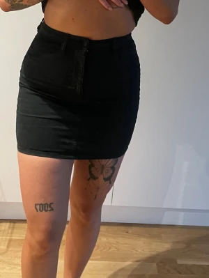 Svart kort jeanskjol - Säljer en svart kort jeanskjol i stretchigt material. 