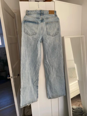 Ljusblå raka jeans  - Säljer ett par ljusblå jeans med raka ben. Jeansen har klassiska fem fickor och en avslappnad passform. Perfekta för en trendig och avslappnad stil. Materialet är 100% denim och de har en snygg tvättad look.