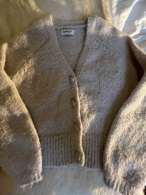 Beige stickad kofta från ONLY -  Säljer denna kofta från Only i storlek XS. Nypris 449 kr för 250 kr. Kan gå ner i pris vid snabb affär. Väldigt fint skick, men liten nopprig. 