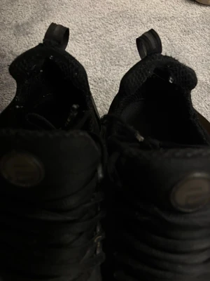 Svarta Nike Air Max sneakers - Säljer ett par helsvarta Nike Air Max sneakers med klassisk luftig mesh och syntetmaterial. Skorna har tydlig Nike-logga på sidan och dragflikar på plösen. Snygg sportig look med robust sula och snörning framtill. Vid fler bilder hör av er!