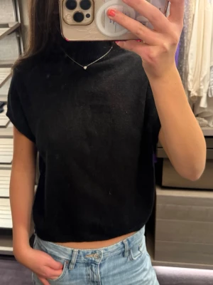 Svart croppad polotopp - Säljer en svart stickad polotopp med korta ärmar. Super bra skick då den inte kommer till användning💗