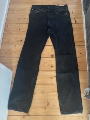 Svarta raka jeans från Weekday - Säljer ett par klassiska svarta jeans från Weekday med rak passform och fem fickor. Jeansen har en enkel design med knappgylf och bälteshällor. Perfekta till vardags för en clean och tidlös look. Storlek: W27L32