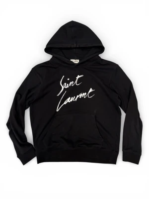 Saint Laurent Hoodie - Fet Saint Laurent Hoodie med ett stilrent vit tryck. Hoodien är så klart ÄKTA Hoodien är i storlek M, han på bilden är 184 och den sitter på gränsen för han Mått 📐 Längd 65cm Axelbredd 50cm Armlängd (från toppen) 57cm (från botten) 50cm  Bara att höra av sig vid intresse eller vid någon fundering☺️!!