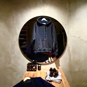 Fet Cohen hoodie - Säljer en mörkblå hoodie från J.Cohen med broderad logga och stiliserad blomdesign på bröstet. Hoodien har en klassisk huva med dragsko och ribbade muddar vid ärmslut och nederkant. Perfekt för dig som gillar stilrena detaljer. Pris inte hugget i sten!