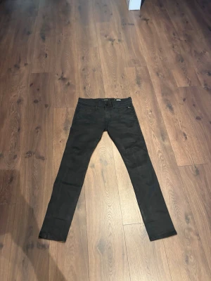 Replay jeans - Säljer ett par svarta slim fit jeans med klassisk femficksdesign och normal midja. Jeansen har raka ben och är tillverkade i ett stretchigt material för extra komfort. Passar perfekt till en avslappnad och stilren look.
