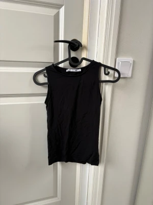 Svart ärmlös linnetopp - Linne med mjukt och luftigt material. Figurnära. Aldrig använd