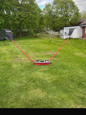 Badmintonset med nät från Kayoba - Säljer ett komplett badmintonset från Kayoba med svart nät och röda stolpar. Perfekt för trädgården eller parken. Nätet är enkelt att montera och har en stabil bas. Allt du behöver för att spela badminton utomhus med vänner!