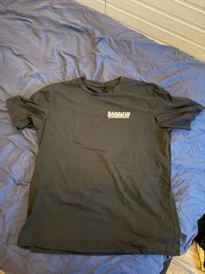 Svart Passion Racing t-shirt - Svart t-shirt från Passion Racing med tryck på bröstet och stort motiv på ryggen med bil och tekniska ritningar. Klassisk passform och rund hals. Perfekt för dig som gillar motorsport och coola prints.