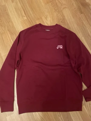 Vinröd sweatshirt Glowbig or Glow Home Margareta grääs - Ny oanvänd Vinröd sweatshirt med tryck fram och stort vitt tryck bak: 'Glowbig or Glow Home' samt sminkmotiv. Rund hals, ribbade muddar och avslappnad passform. Perfekt för dig som gillar statement-plagg och makeup-vibes.