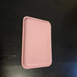 Äkta Apple MagSafe Wallet - Säljer två Apple MagSafe Wallets i rosa och djupgrön. Båda är i nytt skick.. Perfekt tillbehör för iPhone med MagSafe, håller dina kort säkert och stilrent. Original Apple-kvalitet och passform. 