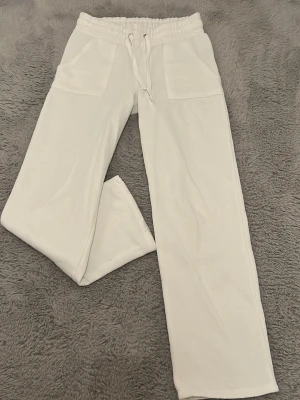 Vita mjukisbyxor med raka ben - Snygga vita mjukisbyxor med raka ben. Byxorna har snörning i midjan, två stora fickor fram och två bakfickor. Perfekta för en chill och avslappnad stil. Mjukt material som känns skönt mot huden. Köpta för ca 1 år sedan för 200kr, använda någon enstaka gång, tror 2 ggr. Inga tecken på användning heller. Säljer då de ej kommer till användning, men som sagt najs till myskvällar samt avslappnade outfits. :))